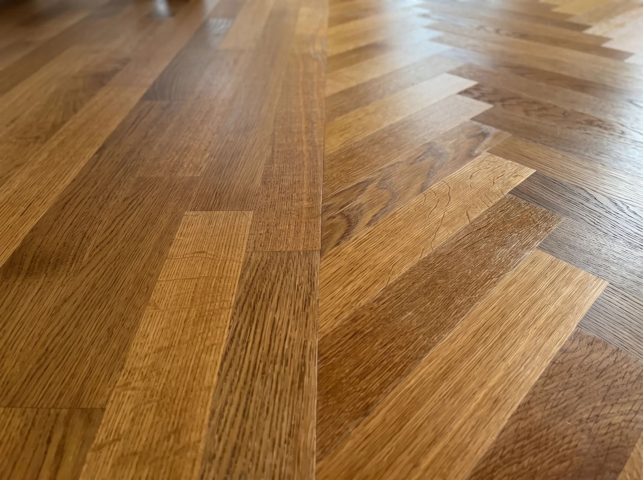 Macro of warm honey-oak natural-wood herringbone