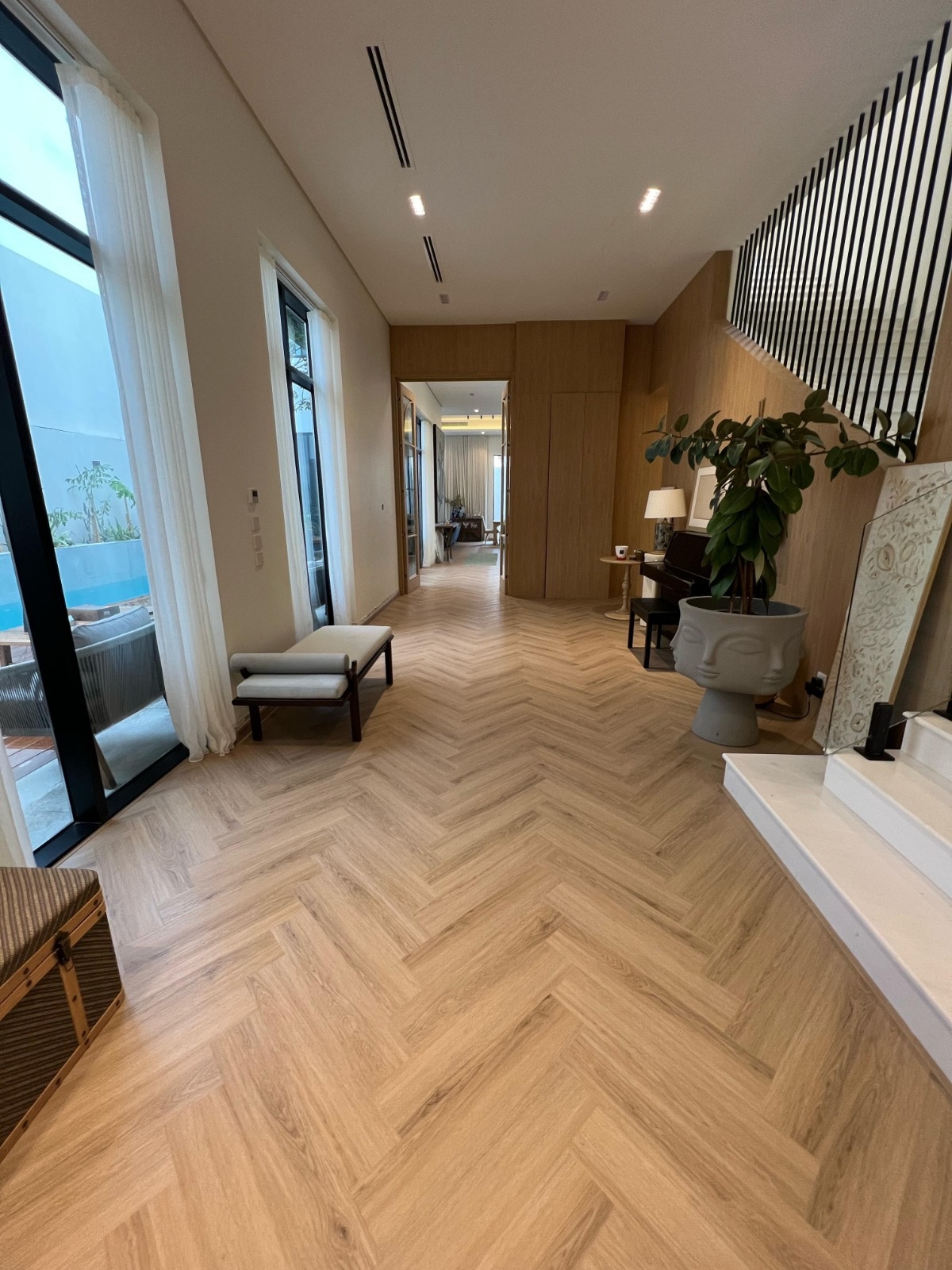 A light herringbone floor leading through a private entrance hall