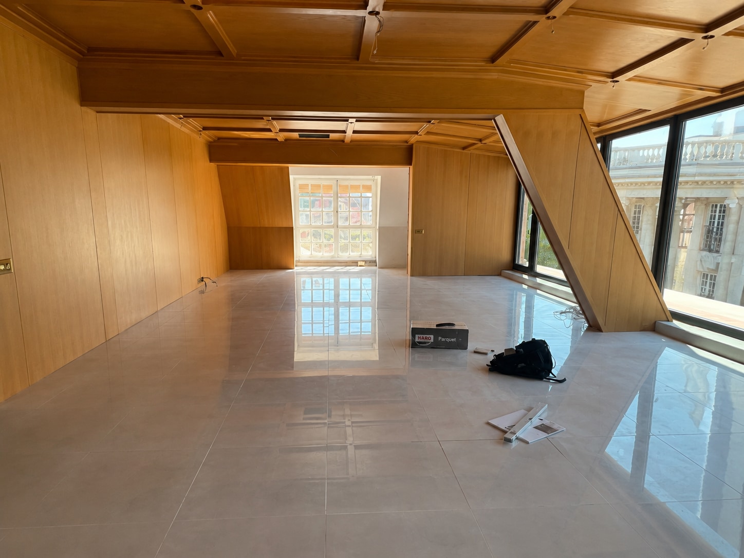 Before — the reflective stone salon beneath its timber ceiling