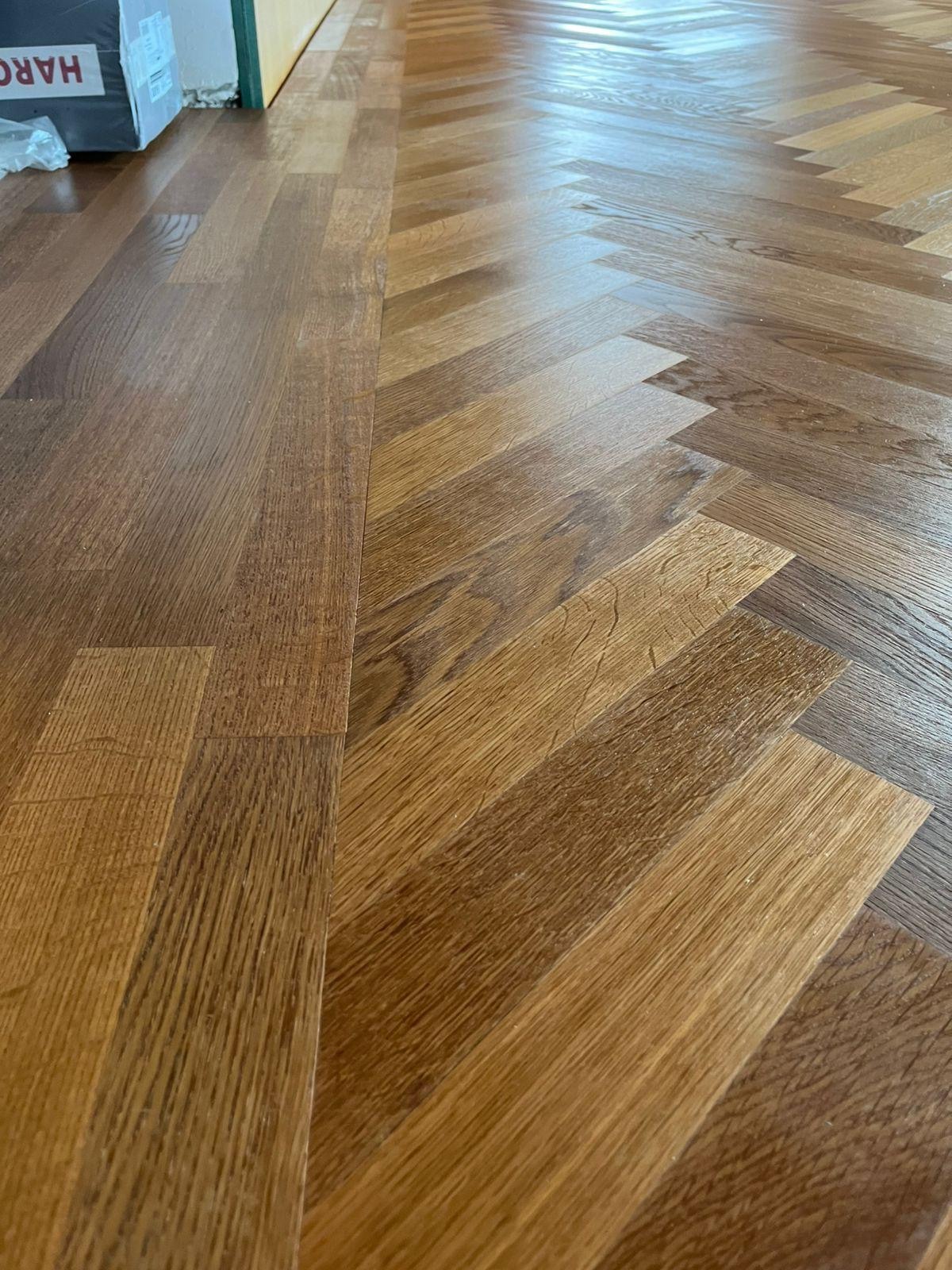 Close detail of wide-plank oak meeting pale stone
